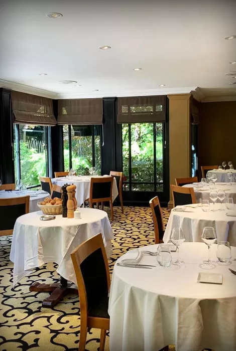 Salle de restaurant La Griotte, tables dressées avec nappes blanches et vaisselle soignée